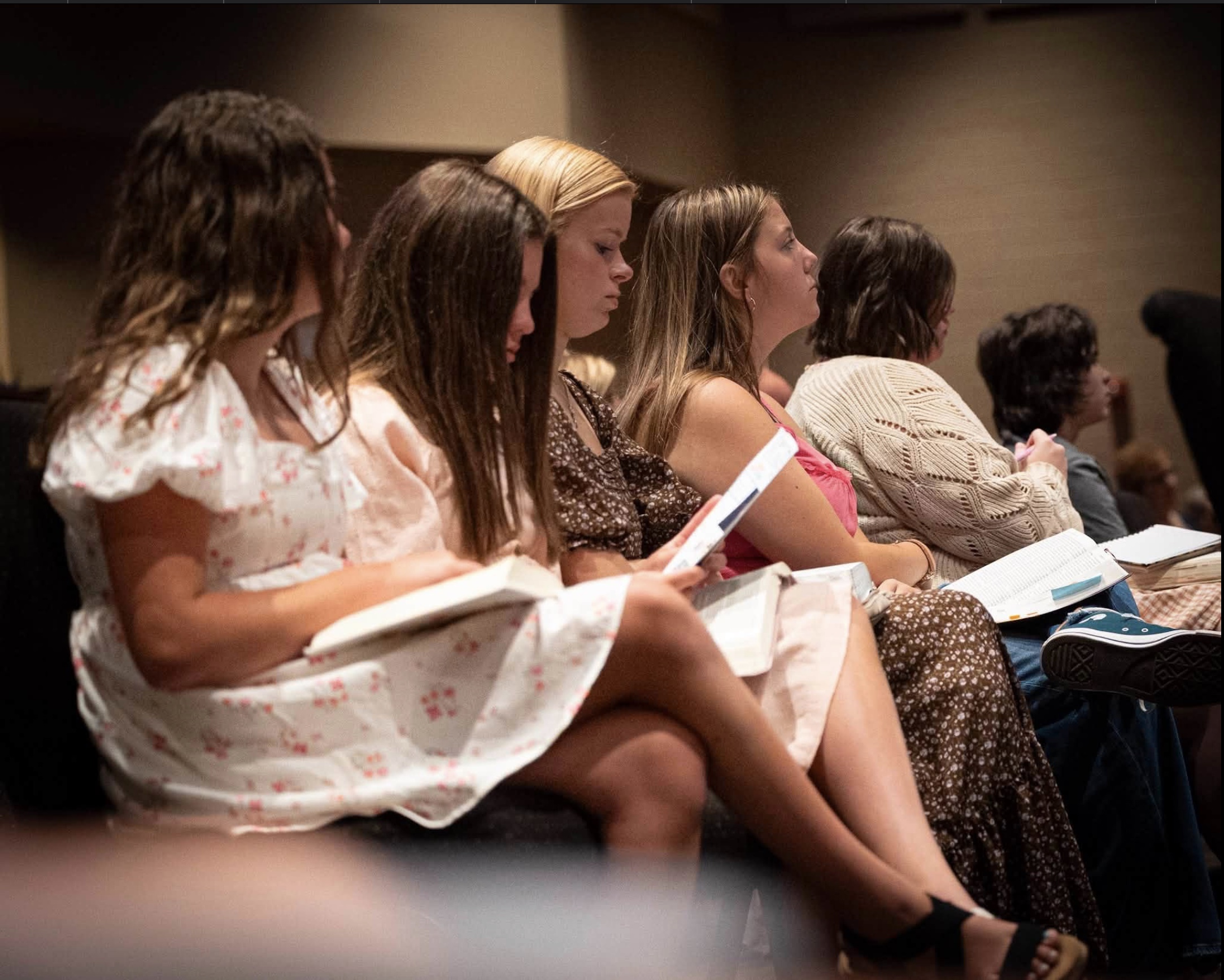 Girls take notes during a church service.